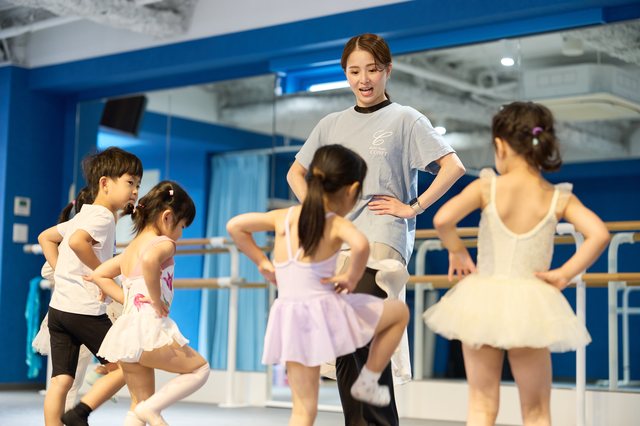 バーにつかまる幼児たちと笑う講師